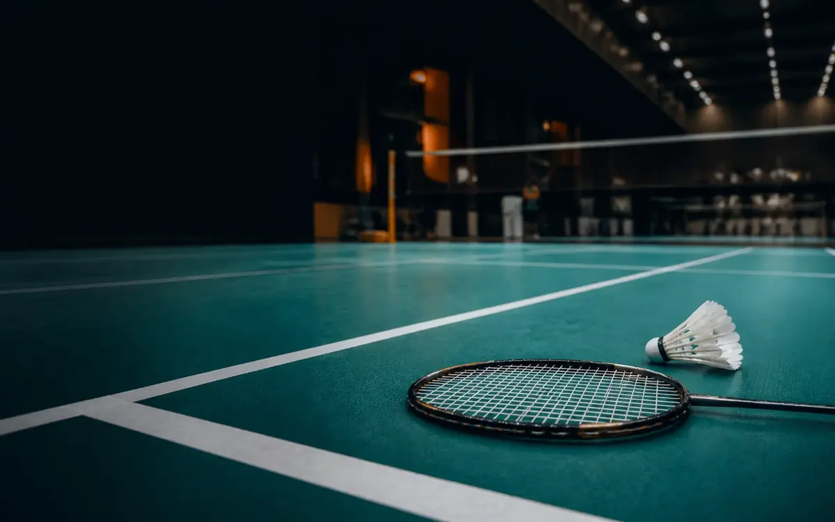 Badminton racket and shuttlecock on an indoor court