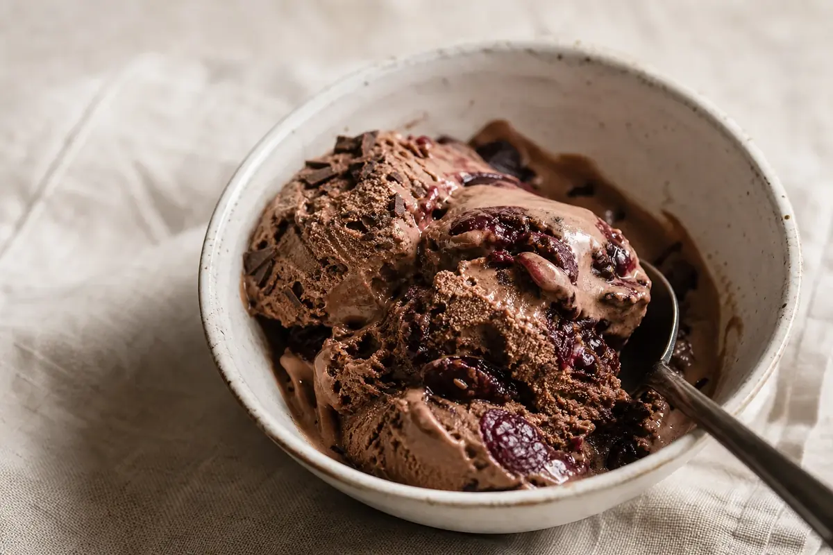 Creamy no-churn dark chocolate ice cream rippled with jammy cherries and crunchy chocolate pieces.